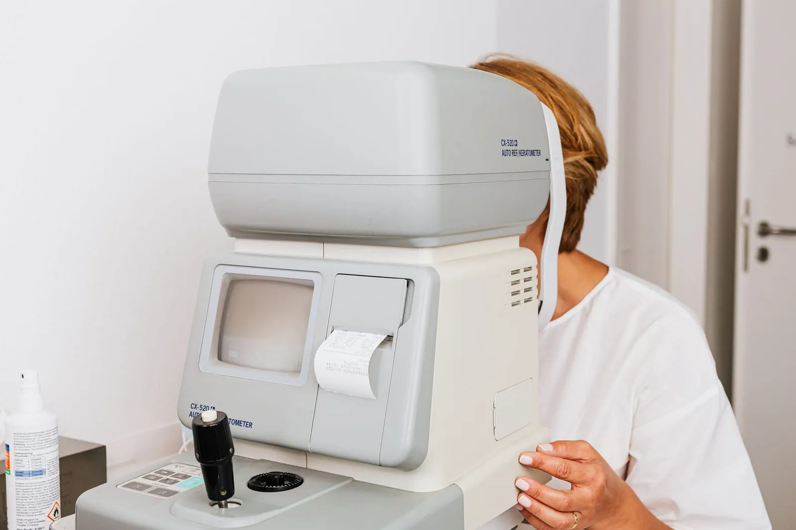 Pacientă la autorefractometru, aparatul care măsoară dioptriile înainte de rețeta de ochelari