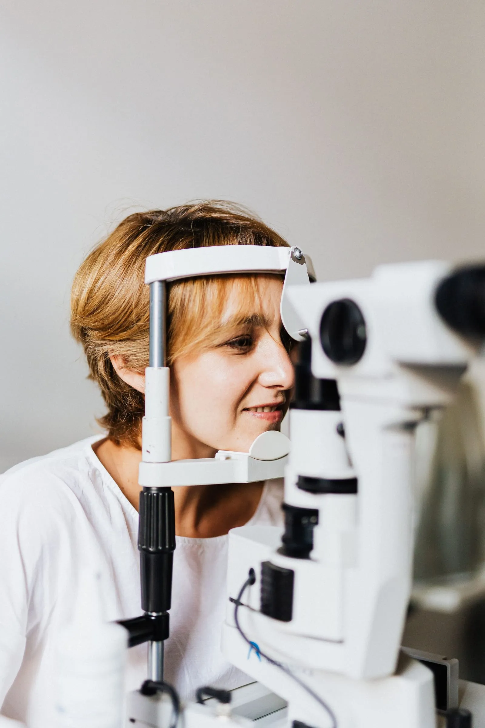 Pacientă la biomicroscop, aparatul cu care se examinează în detaliu ochiul